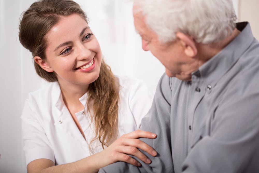 Picture of smiling nurse assisting senior man