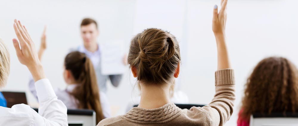 Young teacher in classroom standing in front of class2