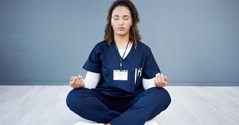 An allied health professional sits cross-legged